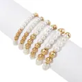 Detail view of 6-piece stacked bracelet set with faux pearls and golden beads on display - Gold