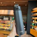 Matte black TYESO insulated stainless steel tumbler with secure lock lid in hand - Black