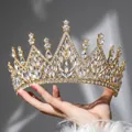 Goldenes Barock-Diadem mit funkelnden Marquise-Strasssteinen in der Hand gehalten - Gold
