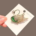Elegant gold swan brooch with green stone and sparkling crystal accents on display card - Green Swan Style (B10)