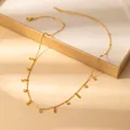 Detail of gold infinity charm necklace with zircon accents on a beige jewelry case - Infinity Symbol (X637) / Gold