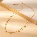 Detailed macro view of gold-plated heart charms and cubic zirconia on a delicate chain necklace - Heart Pendant (X638) / Gold