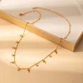 Detail of gold petal necklace featuring crystal zircons and cross charms on jewelry box - Cross (X644) / Gold