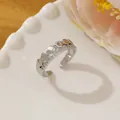 Close-up of a silver hexagonal micro-pave ring on a white plate with floral accents - Adjustable Open / Silver Geometric Hexagon Style (N)