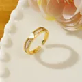 Detailed view of an adjustable gold heart ring with rectangular zircon stones on a ceramic plate - Adjustable Open / Gold Heart Enamel Baguette Diamond Style (I1)