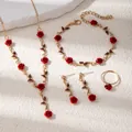 Flat lay detail of red rose jewelry set including necklace, bracelet, ring and earrings - Necklace Bracelet Earrings And Ring Set (E4431-3) / Gold/Red