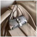 Detail of silver metallic underarm bag with vintage texture and large metal buckle - Silver