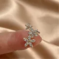 Clip d'oreille doré à fleurs avec strass étincelants dans un design incurvé et élégant - Or