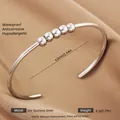 Polished silver stainless steel open bangle with five movable beads on brown silk fabric - Silver Five Sphere Style