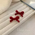 Pair of 2.6cm mini red velvet bow hair clips for women and children on display - One Red Flocked Bow