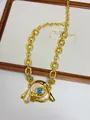 Detailed macro view of gold evil eye pendant with blue enamel and pearl tassels - Oil-stained Blue Evil Eye Necklace Xl2854