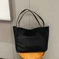 Minimalist large capacity black canvas tote bag with functional front pocket for daily use - Black