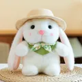 White plush bunny wearing a straw hat and green floral scarf sitting on a mat - White