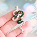 Elegant silver-tone snake brooch adorned with sparkling green crystals and rhinestones - Silver with Green Zircon