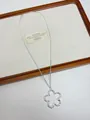 Close-up of a silver-tone open flower pendant on a minimalist metal chain necklace. - Silver Melted Flower