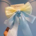 Detail of handmade organza bow hair clip in pastel yellow and blue on brand card - Yellow and Blue Ribbon Duckbill Clip