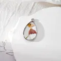 Ciondolo a goccia in resina con vere fioriture essiccate arancioni e cornice d'argento - Erba Danzante/Arancione