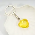 Yellow heart-shaped acrylic crystal keychain with faceted cut on a white tray - Gold Yellow / Silver
