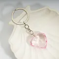 Pink heart-shaped crystal keychain with silver multi-link chain on white shell dish - Pink / Silver