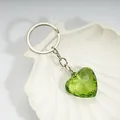 Sweet green heart crystal keychain with silver chain on a white shell tray - Dark Green / Silver