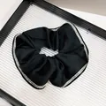 Detailed close-up of a black satin scrunchie featuring elegant double-row rhinestone edges - Satin Double Row Rhinestone Style