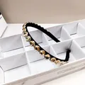 Detailed close-up of champagne amber crystals on a luxury black headband for women - Champagne