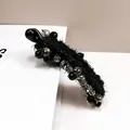 Elegante pinza tipo banana de tweed negro con cristales gris humo y detalles dorados - Negro