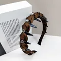 Detail of brown pleated fabric headband with black spikes and sparkling rhinestones - Round Crystal Style / Coffee