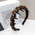 Macro detail of gothic pleated headband with black metal spikes and sparkling rhinestones - Oval Crystal Style / Coffee
