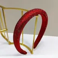 Detail of red padded sponge headband with sparkling rhinestones on minimalist gold rack - Red