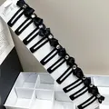 Detail of 10-piece black bow hair clips with central crystal rhinestones on display card - Crystal Square Clip Bow