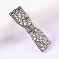 Close-up of sparkling rhinestone bow hair clip with luxury crystal details and black base - White