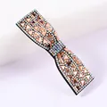 Close-up of bow hair clip with sparkling pink rhinestones and high-shine gems - Champagne (Aurora)