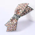 Primer plano del pasador de lazo con triángulos de cristal rosa y pedrería brillante - Champaña con diamantes AB irisados