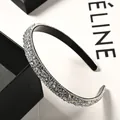 Close-up of sparkling rhinestone headband with crystal embellishment on black frame - White Crystal