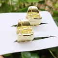Pair of mini matte gold metal hair claws on display card with green plant background - 1.5cm / Mini Claw / Matte Gold