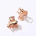 Macro view of rose gold fish-shaped metal hair clips with sparkling rhinestone eyes - Dolphin