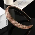 Elegante diadema color champán con brillantes pedrería sobre una superficie negra lisa - Estilo Completo Strass Cristal Champaña