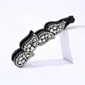 Close-up of sparkling rhinestone hair clip with multi-colored crystals on black resin - White Zircon