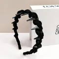 Elegante cerchietto nero intrecciato con punte scure lucide e finitura glitterata - Stile Punte Intrecciato