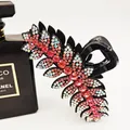 Black hair claw clip featuring sparkling red and white rhinestone feather design - Pink