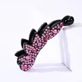 Nahaufnahme der schwarzen Bananenspange mit rosa Strasssteinen für elegante Frisuren - Rosa Strass
