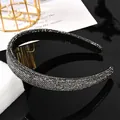 Vista macro de la diadema con cristales grises sobre una superficie reflectante negra - Estilo Completo Strass Gris Mineral