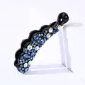 Détail de pince à cheveux banane avec strass bleus et arc-en-ciel sur résine noire ondulée - Petit Bord Ondulé / Bleu