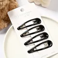Detalle de cuatro pinzas para el cabello BB negras brillantes en tarjeta blanca - Pinza de Gota Pintura Negra 6cm (NM-6621) / Paquete de 4 / Negro