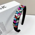 Detalle macro de diamantes de imitación multicolores en una diadema de terciopelo negro - Multicolor