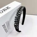 Diadema elegante de terciopelo negro con cristales grises brillantes sobre libro blanco - Gris ahumado