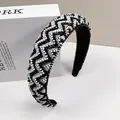 Close-up of wide padded headband featuring handcrafted black and white beaded geometric patterns - Black and White