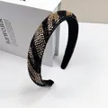 Detail eines handgefertigten Perlenhaarreifens mit schwarzen und goldenen Perlenstreifen - Schwarz Champagner