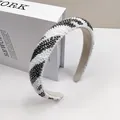 Detail eines Perlen-Haarreifs mit silbernen und weißen Wellenmustern auf einem breiten Band - Off-White